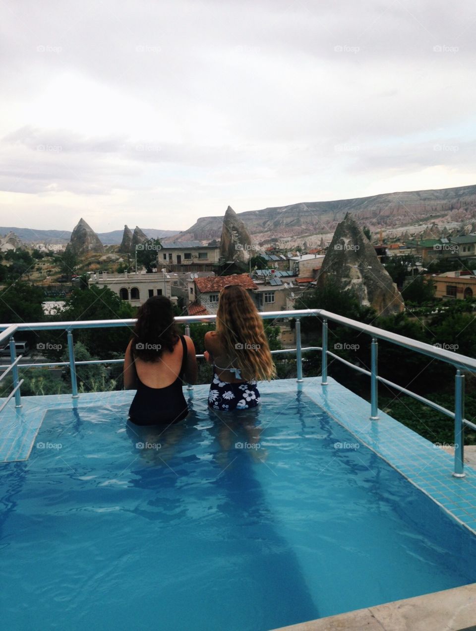 Two girls overlooking Cappadocia, Turkey from a rooftop jacuzzi 