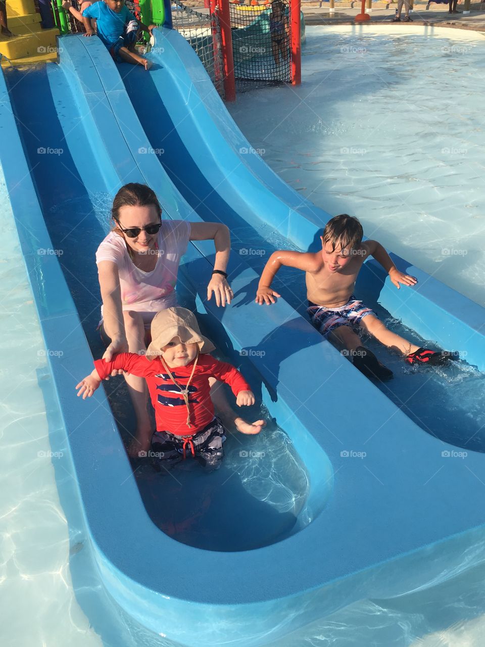Mom and two kids on water slide at water park