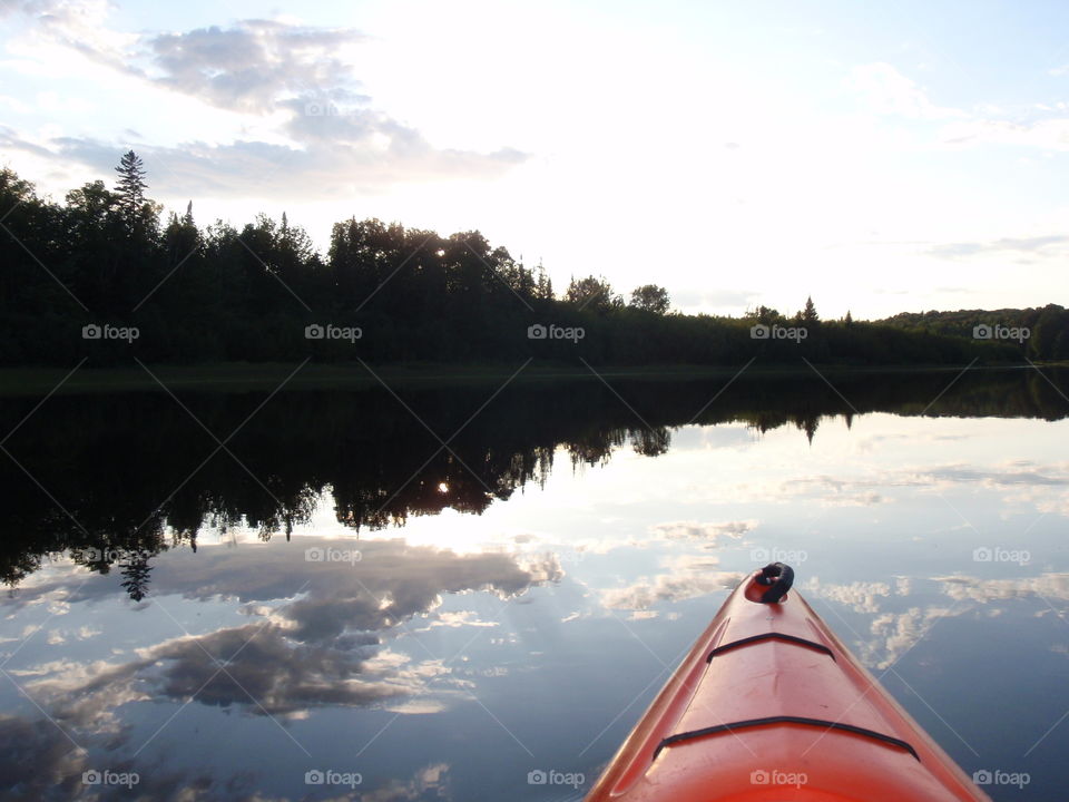 Kayaking in the clouds. Kayaking on beautiful reflective northern Michigan lake