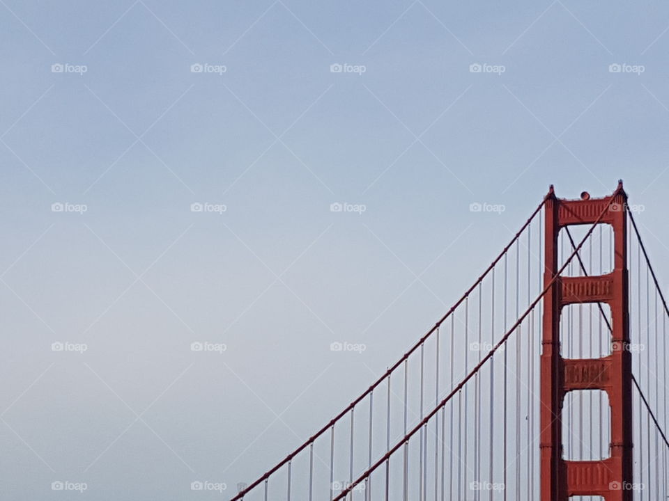 side view of red colored Golden Gate Bridge in San Francisco, America, on cloudy blue sky day