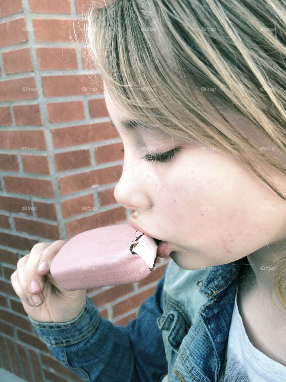 Eating ice cream. Girl eating ice cream in the spring sun