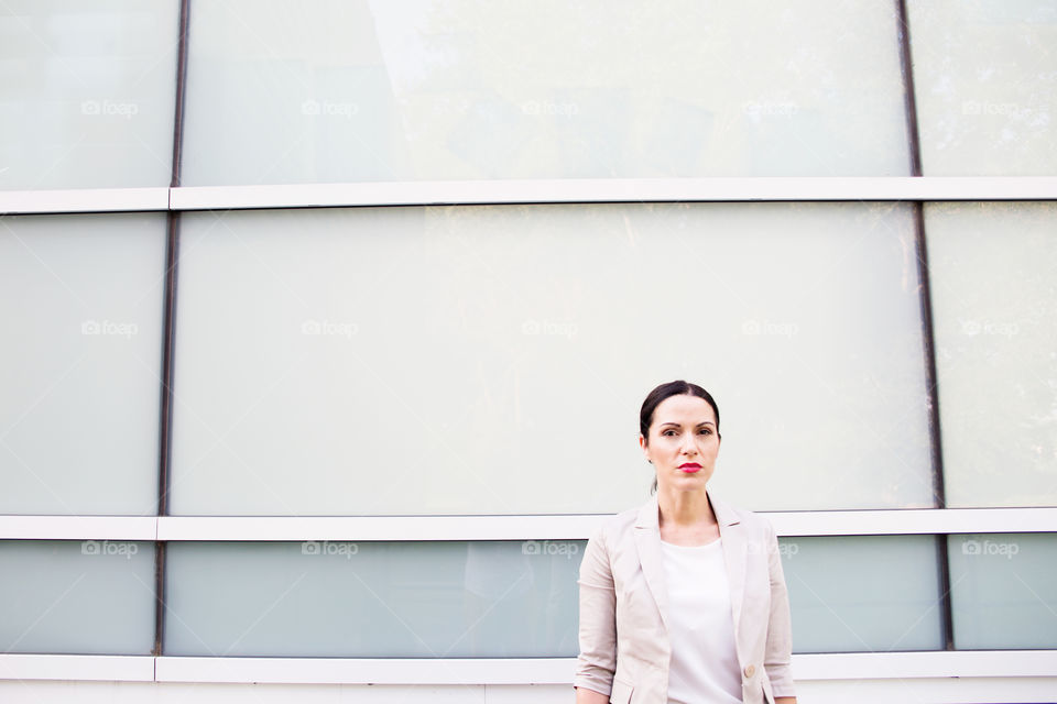 Portrait of mature woman against building wall