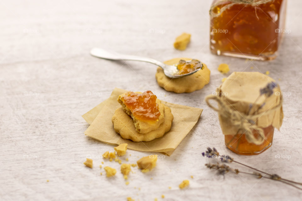 Still life made by biscuits with jam and glases jar with homemade jam on the table.