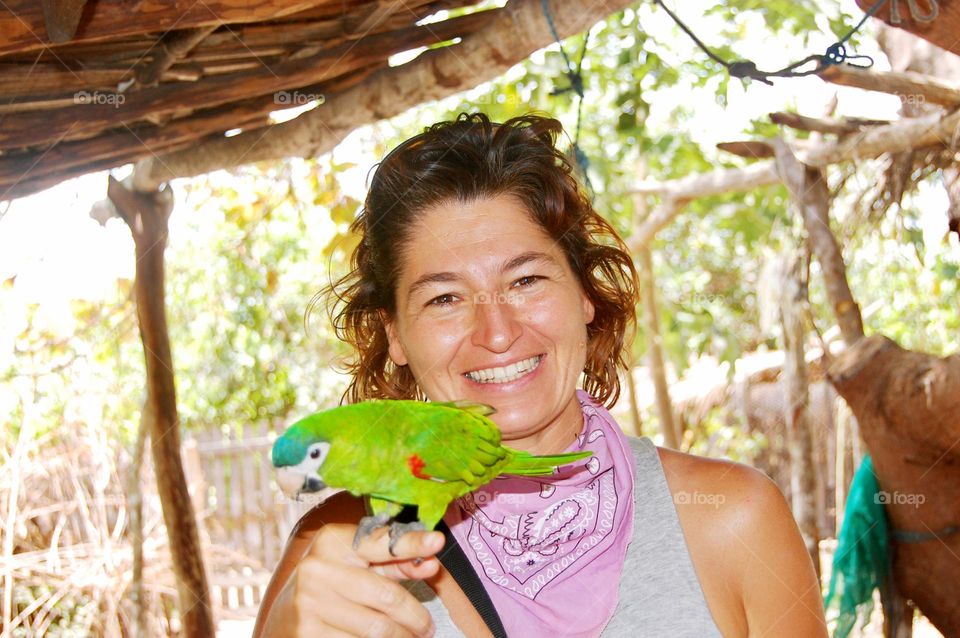 Woman smiling with green parrot 