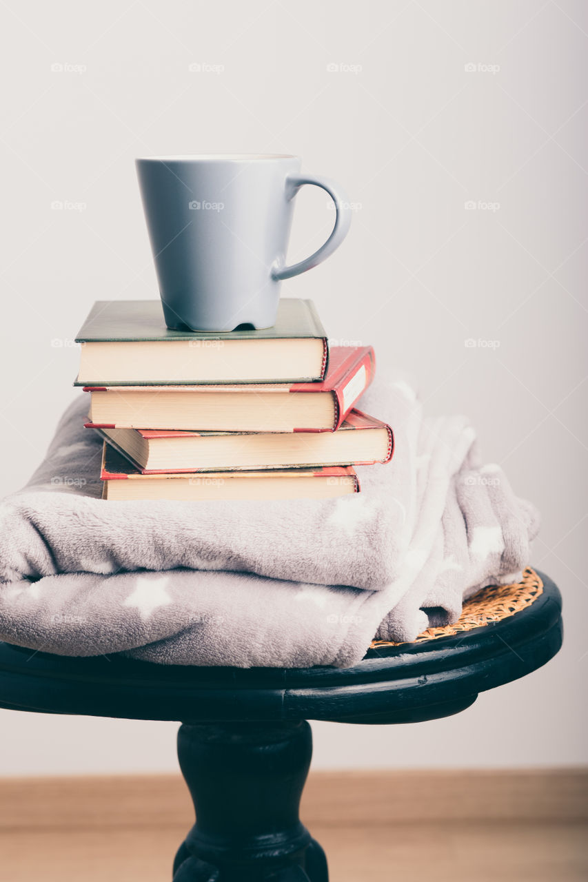 A few books with cup of coffee and blanket. Cozy and comfortable. Time for relax. Spending leisure time on reading. Learning from books. Studying for the next exams