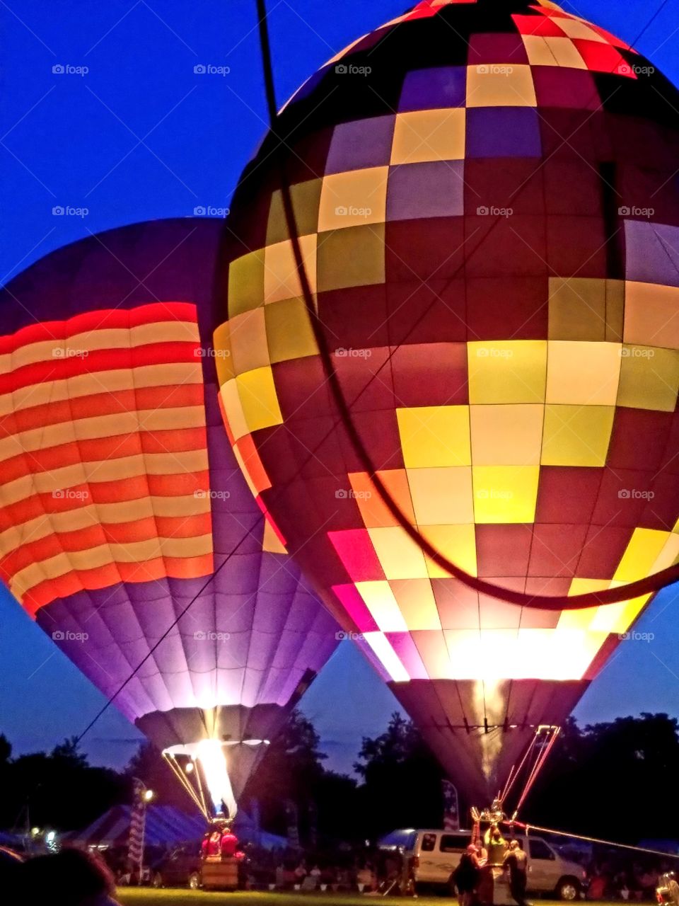 Hot air balloons illuminated during a summer festival.