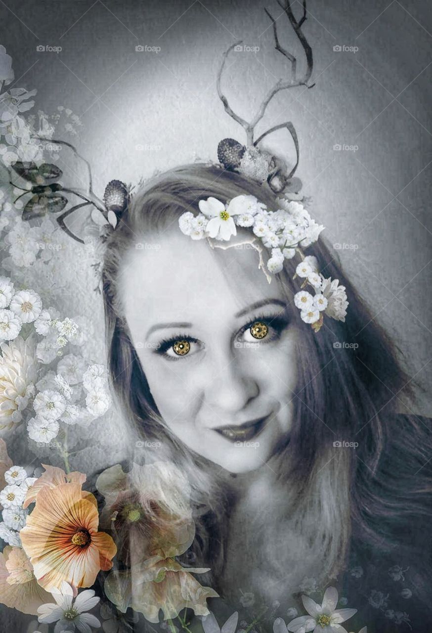 Black and White photo with small highlights of color. Picture of a fairy cosplay with a woman in antlers with flowers.