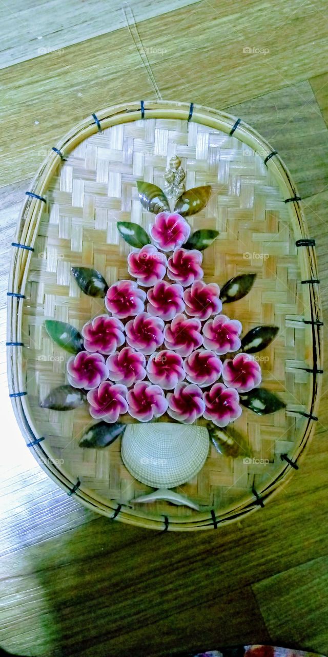 The Flowers in Vase that's made from shell's and the back ground  made from bamboo. this product was made from philippines.