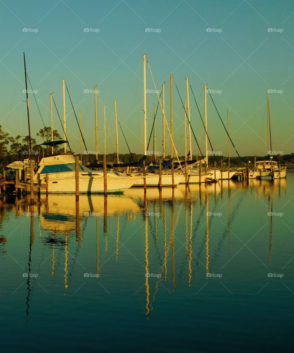 Sailboats resting in the reflection of the shimmering bay!
Sunrise reflects off the sailboats and projects onto the bay water!