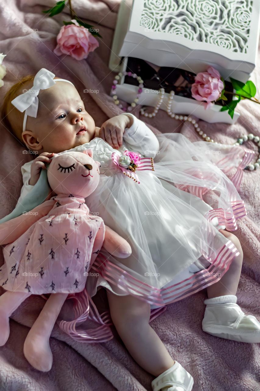 Baby in pink dress with rabbit 