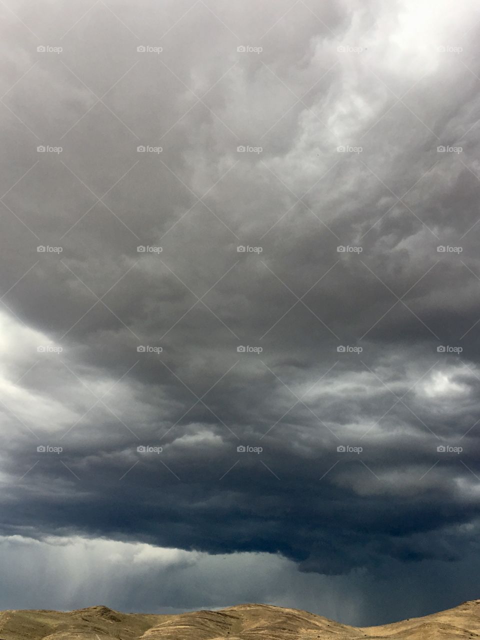 Dark and ominous clouds and severe weather system and thunderstorm over the Sierra Nevada mountains 