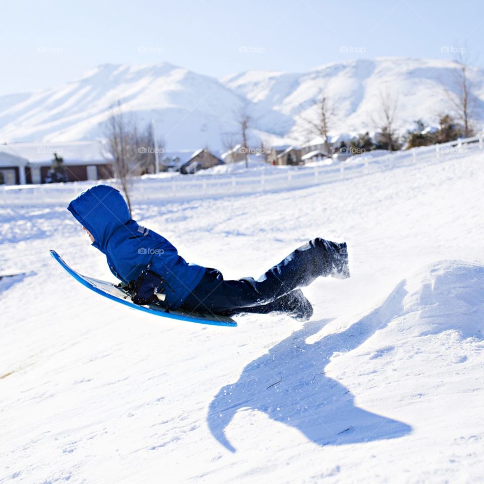 Boy sledding down a hill