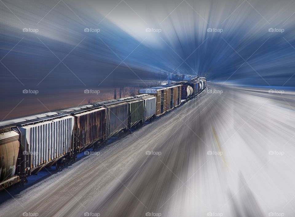 Motion blur of train passing through rail yards in rural area