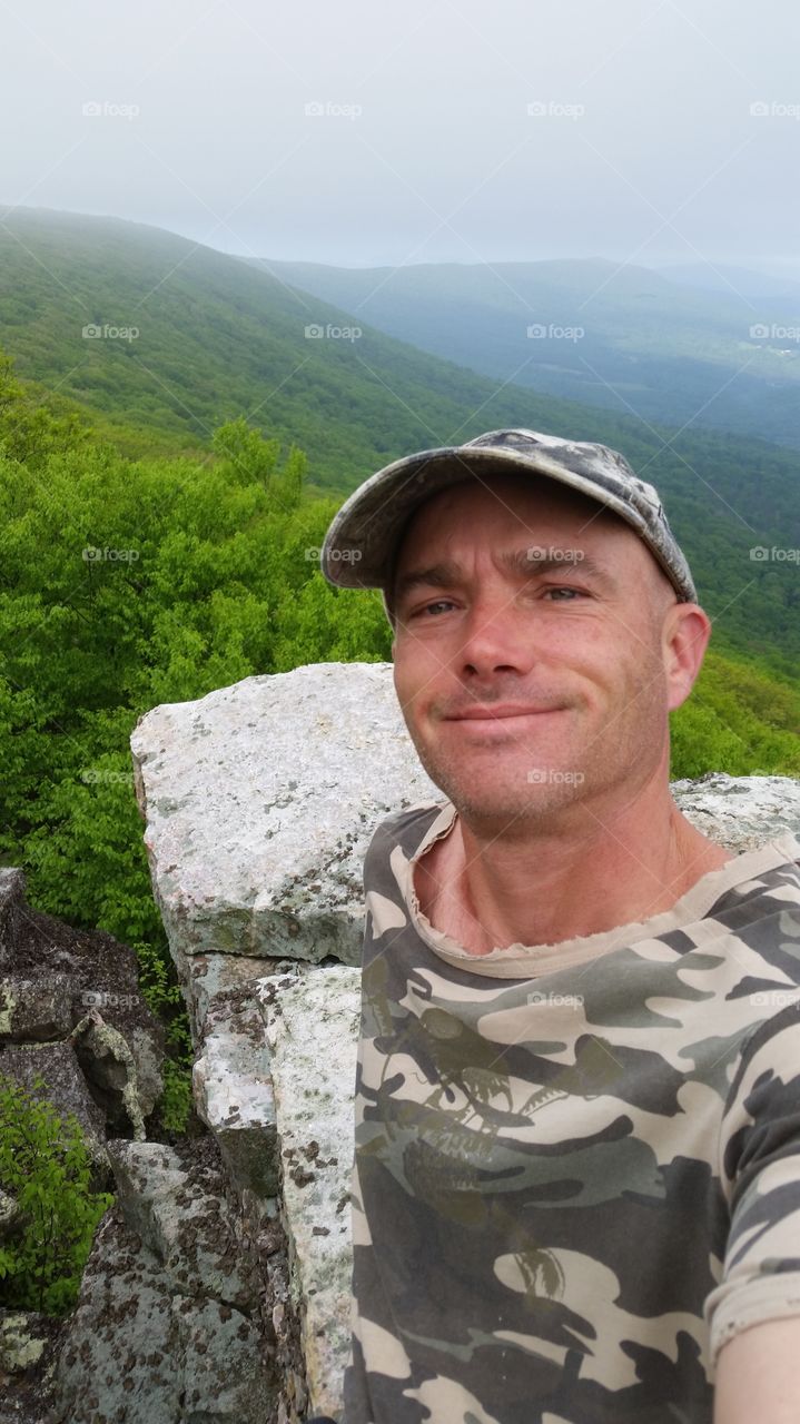 Portrait of happy man in front mountain