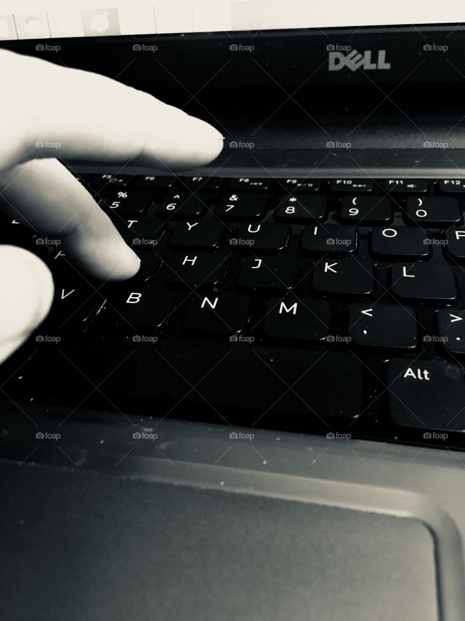 A close up of a woman’s hand typing on a laptop keyboard 