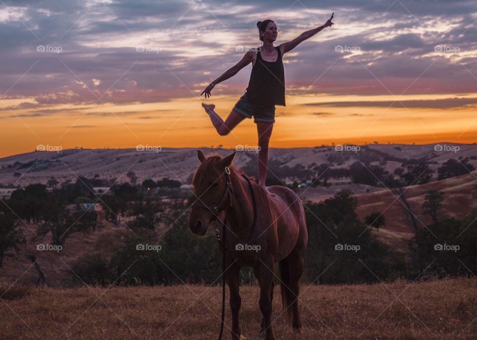 Ballerina dancing in the dark, on a horse, in the sunset.