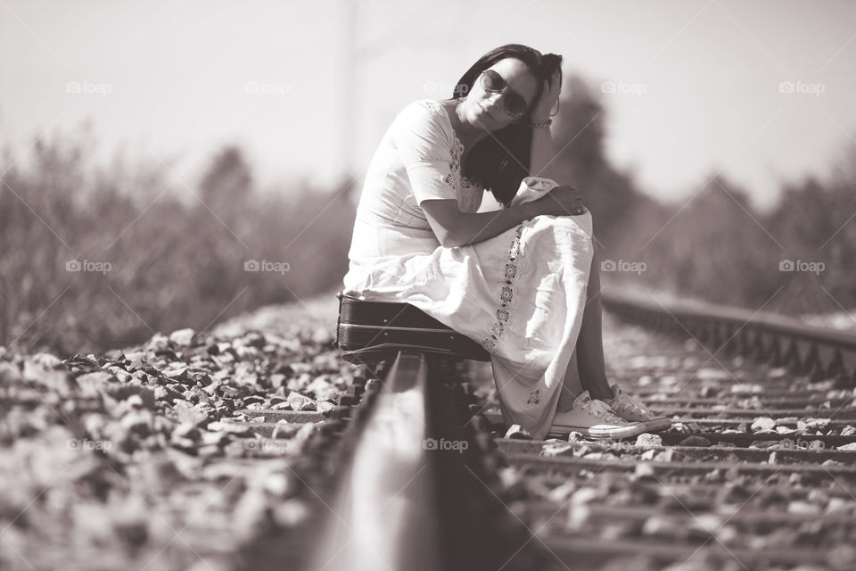 Woman sitting on a railroad 