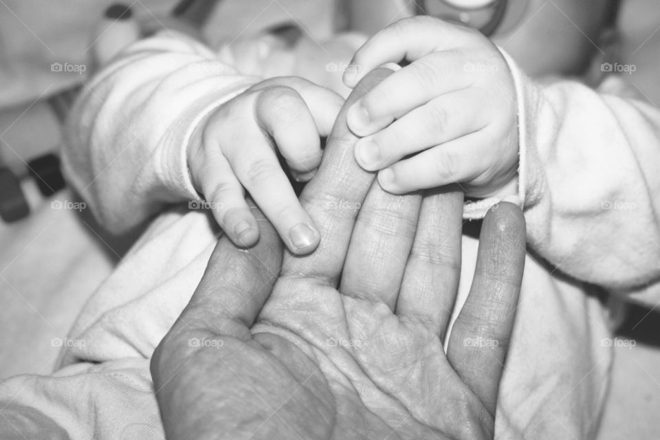 baby holds mother's hand