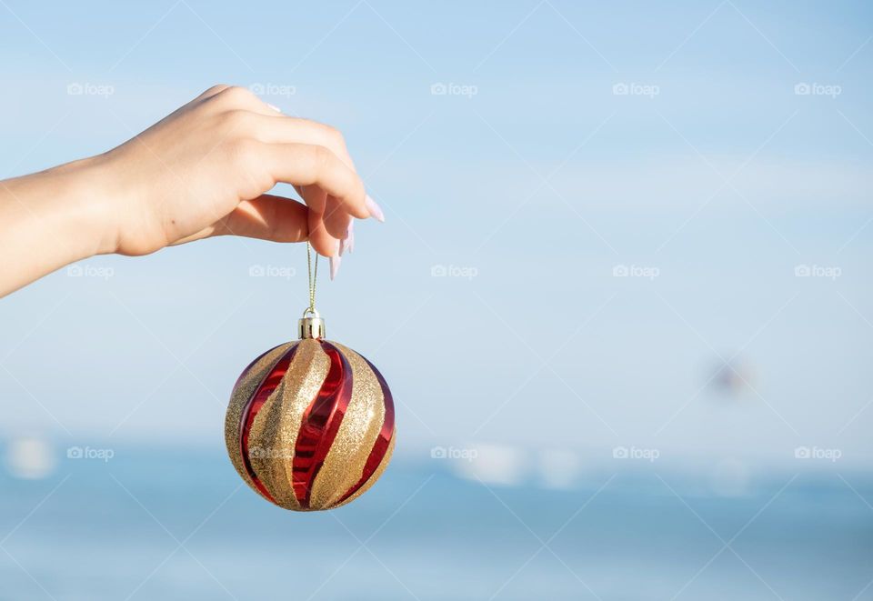 hand holding a Red Ball over Seaside