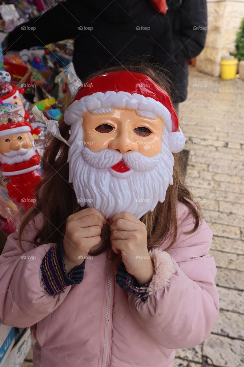 A girl with Santa face mask