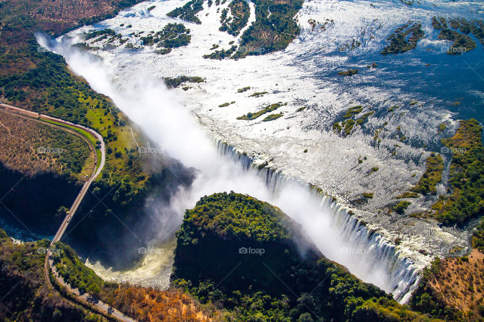 Aerial image of the Victoria Falls, one of the seven natural wonders of the world. The Vic falls forms the border between Zimbabwe and Zambia, Africa. The waterfall is the largest stretching 1708km (5604ft) and is 108m (354ft) high.