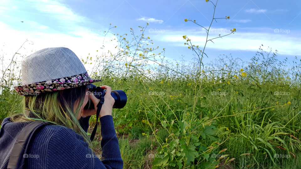 lady holding dslr camera, taking a photo of the blooms during spring