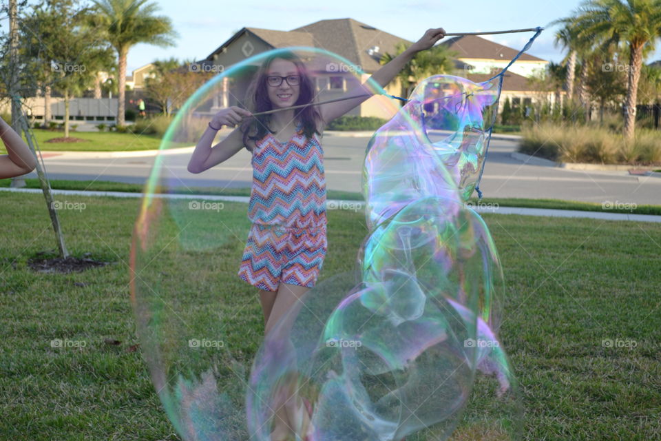 A girl blowing giant soap bubble