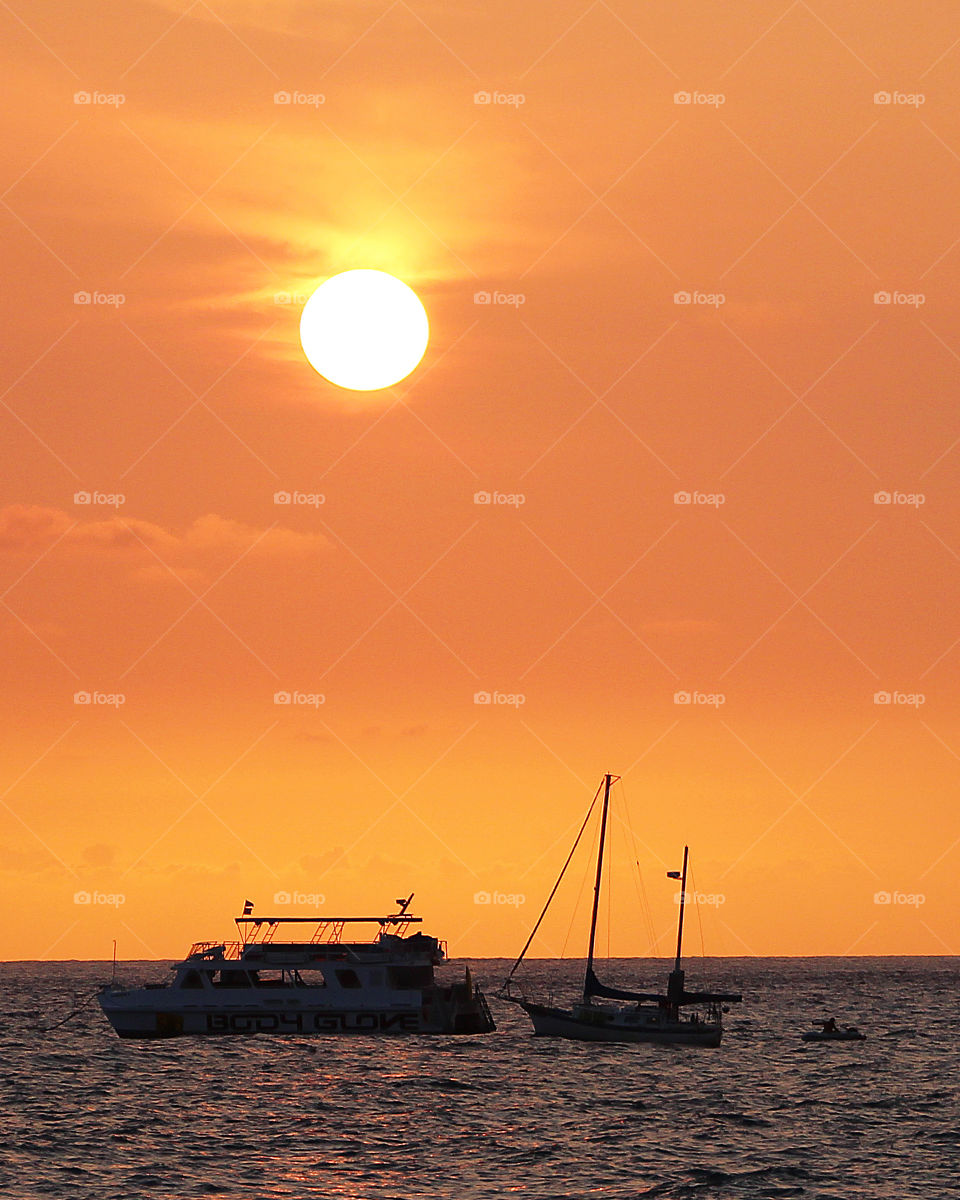 Boats silhouetted in the setting sun