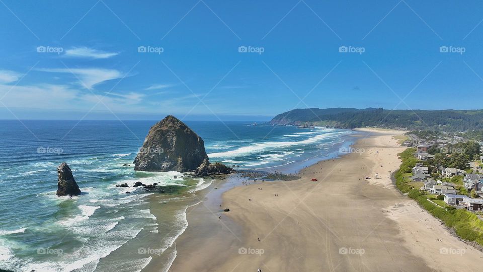 Marvel at the majesty of Haystack Rock in Cannon Beach from a Birds Eye view. Towering against the Pacific Ocean this iconic sea stack stands as a testament to natures grandeur. Aerial photography at its finest capturing the rugged beauty of the PNW