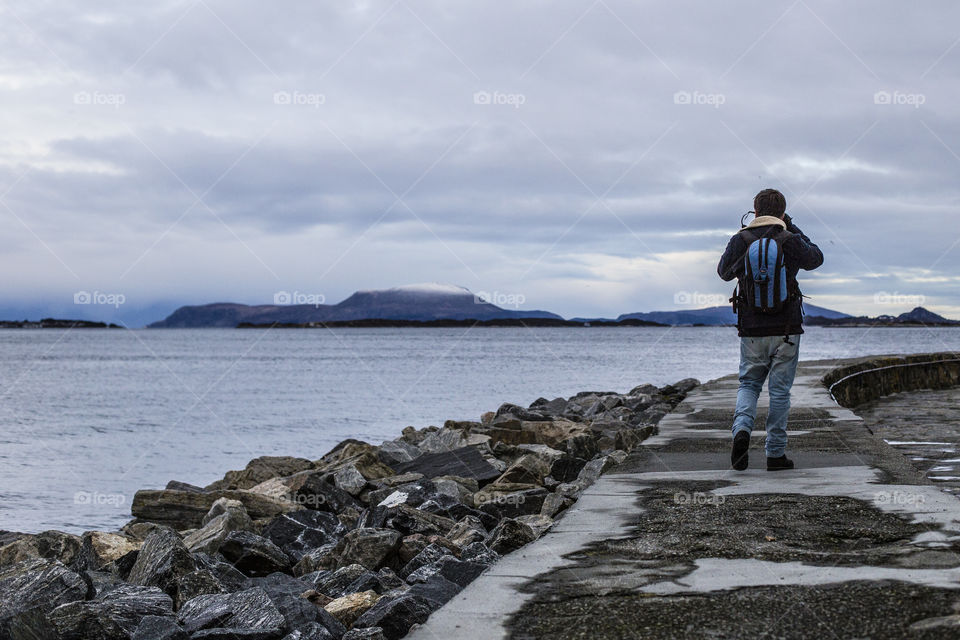 Boy walks near the sea in Alesund 
