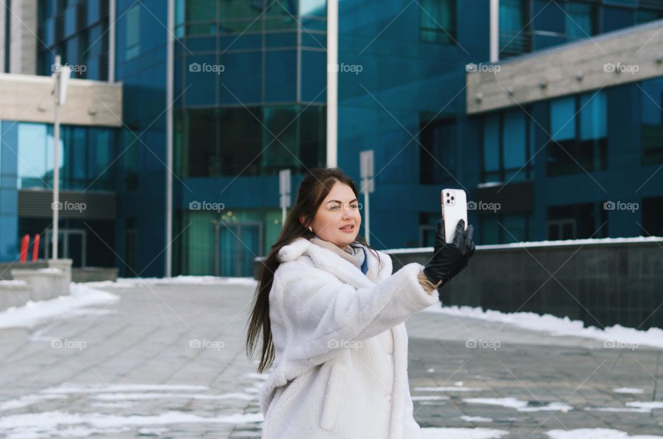 Portrait of young happy business woman relaxing, working in winter city. Laptop. Phone. Technology. Selfie. Social media. Video call