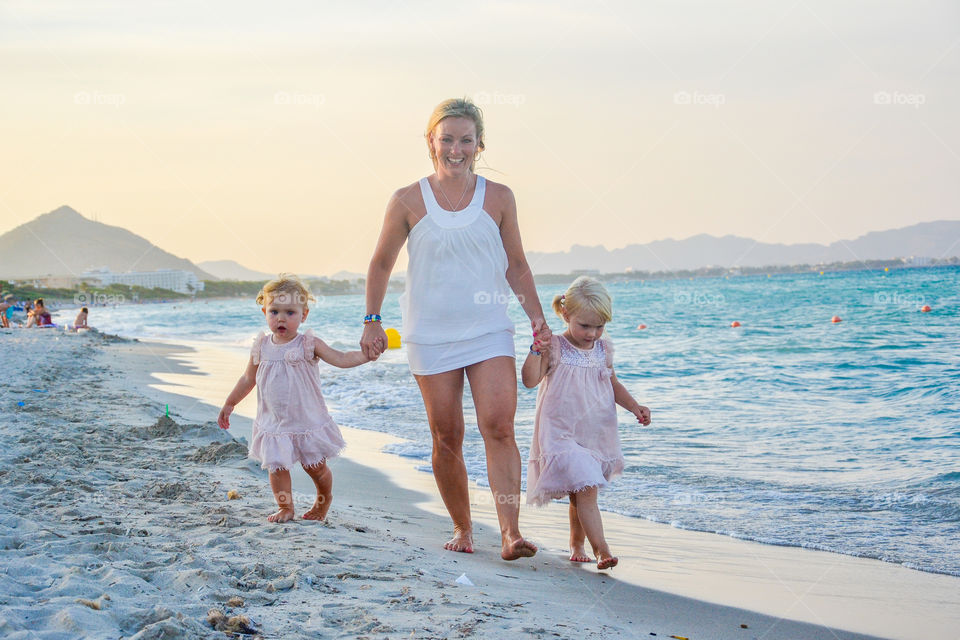 Mother with her daughters walking at beach