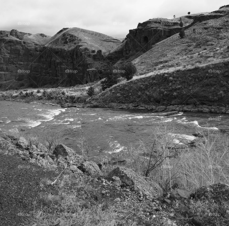 The John Day River in Eastern Oregon flows through a canyon with hills full of caves. 