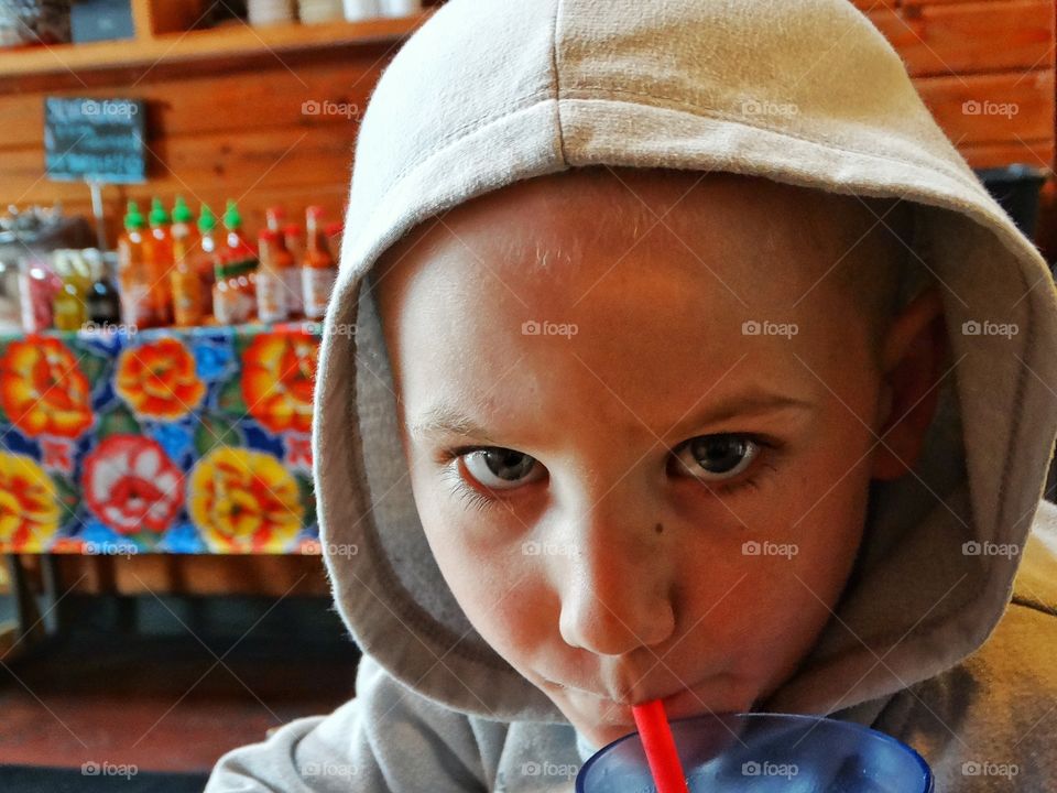 Boy Drinking Through A Straw
