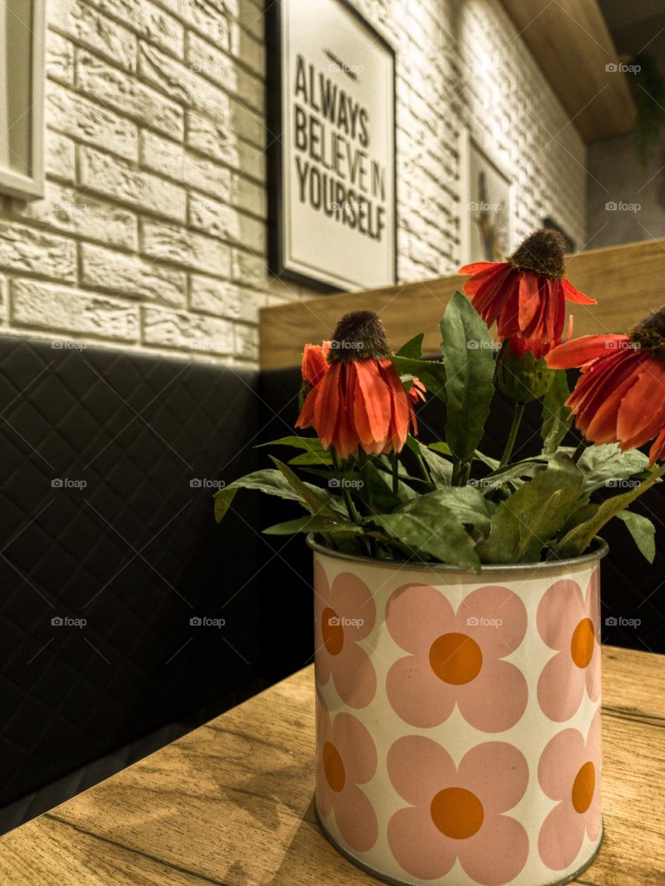 Artificial flowers in a vase on the table.