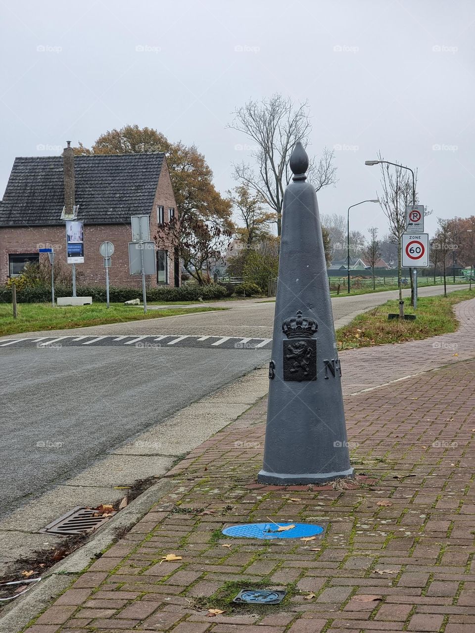 Historical stone border marker at the border between Belgium and the Netherlands, with the coat of arms of the Netherlands