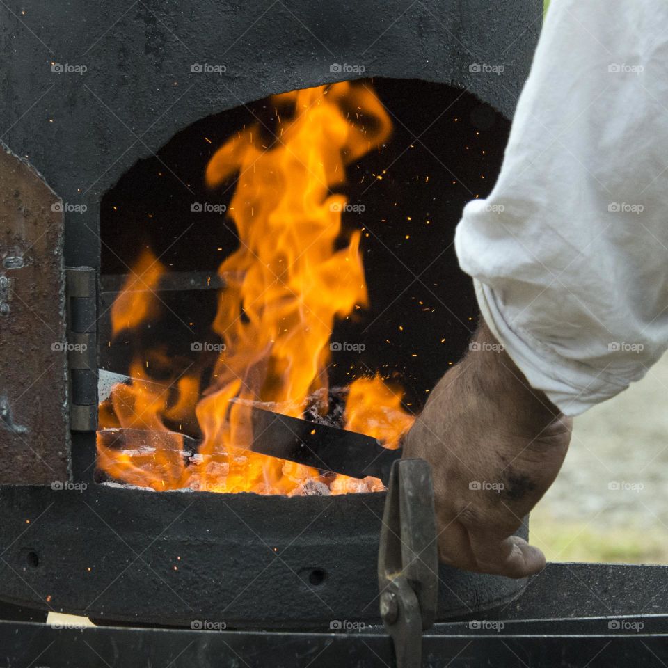 Blacksmith forging steel in a fire