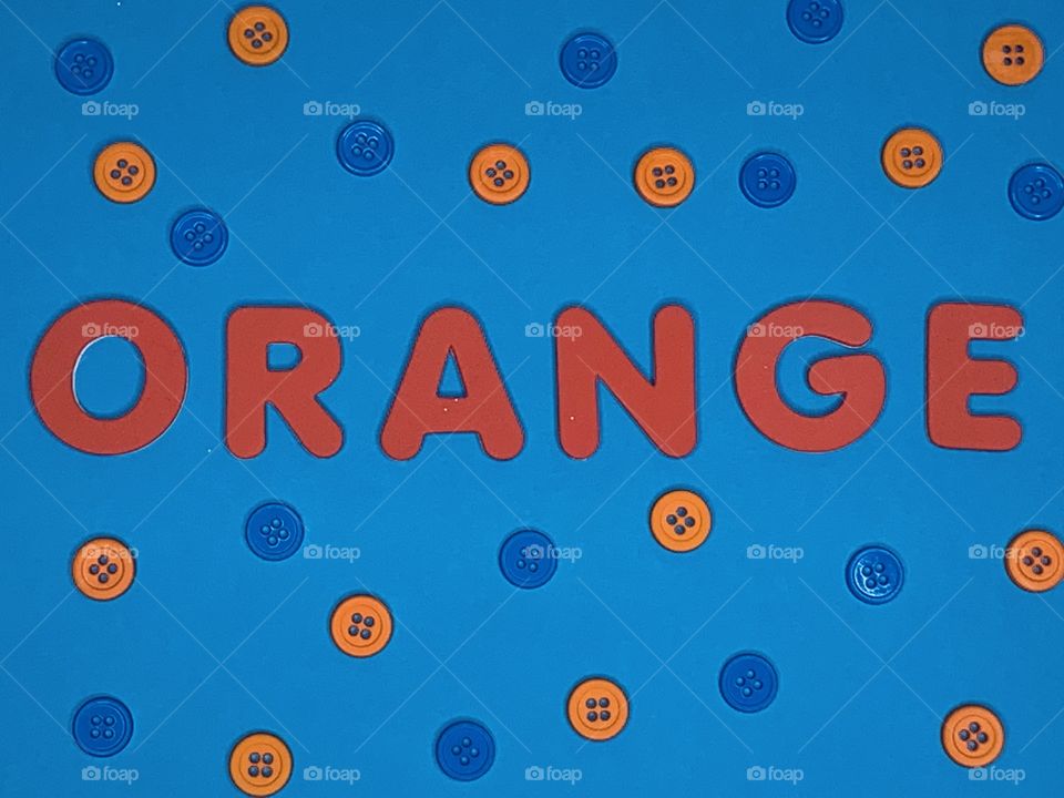 Blue x Orange  - The word orange on a light blue background surrounded by blue and orange buttons