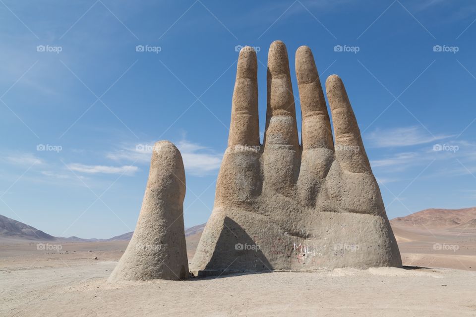 Hand of the desert statue. Mano del Desierto, hand of the desert statue in northern Chile. Clear blue sky. Few hills on the back ground.