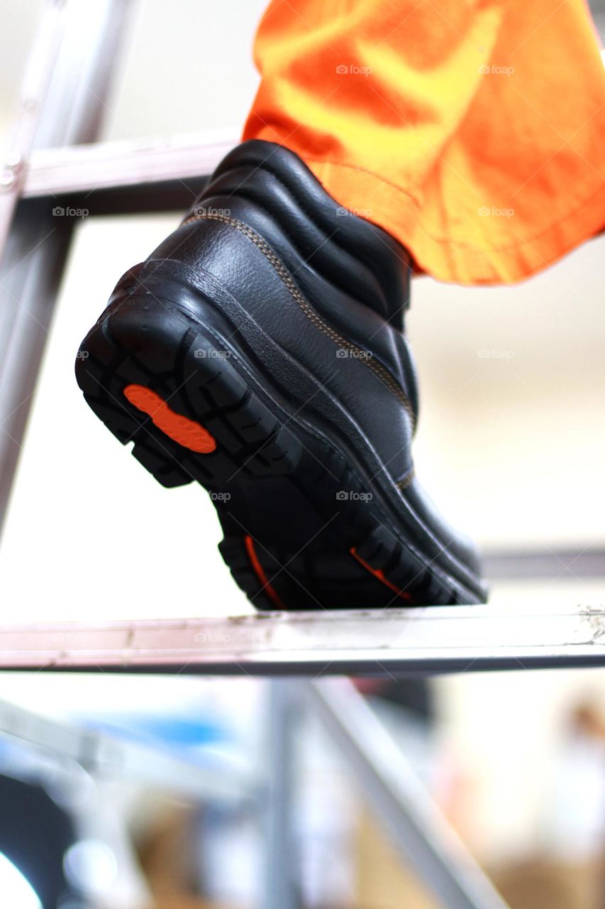 Photo of workers climbing stairs wearing uniforms and safety shoes to fix something