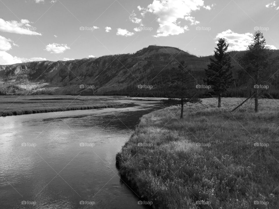 Meandering peace. A river flows peacefully through a field towards the hills. 