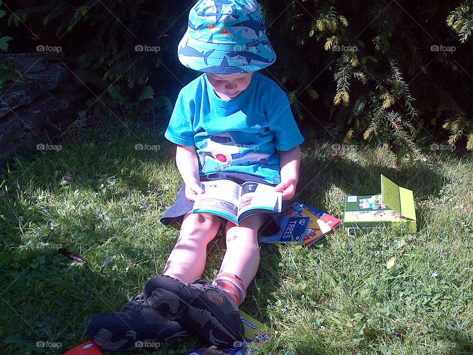 EXPLORER STUDYING HIS I-SPY BOOKS