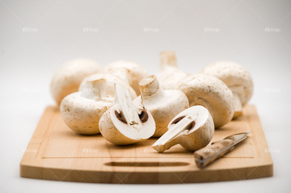 Mushrooms champignons on wooden cutting board and knife
