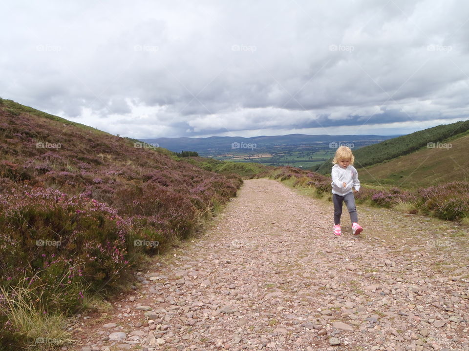 Little girl walking on path along with grass