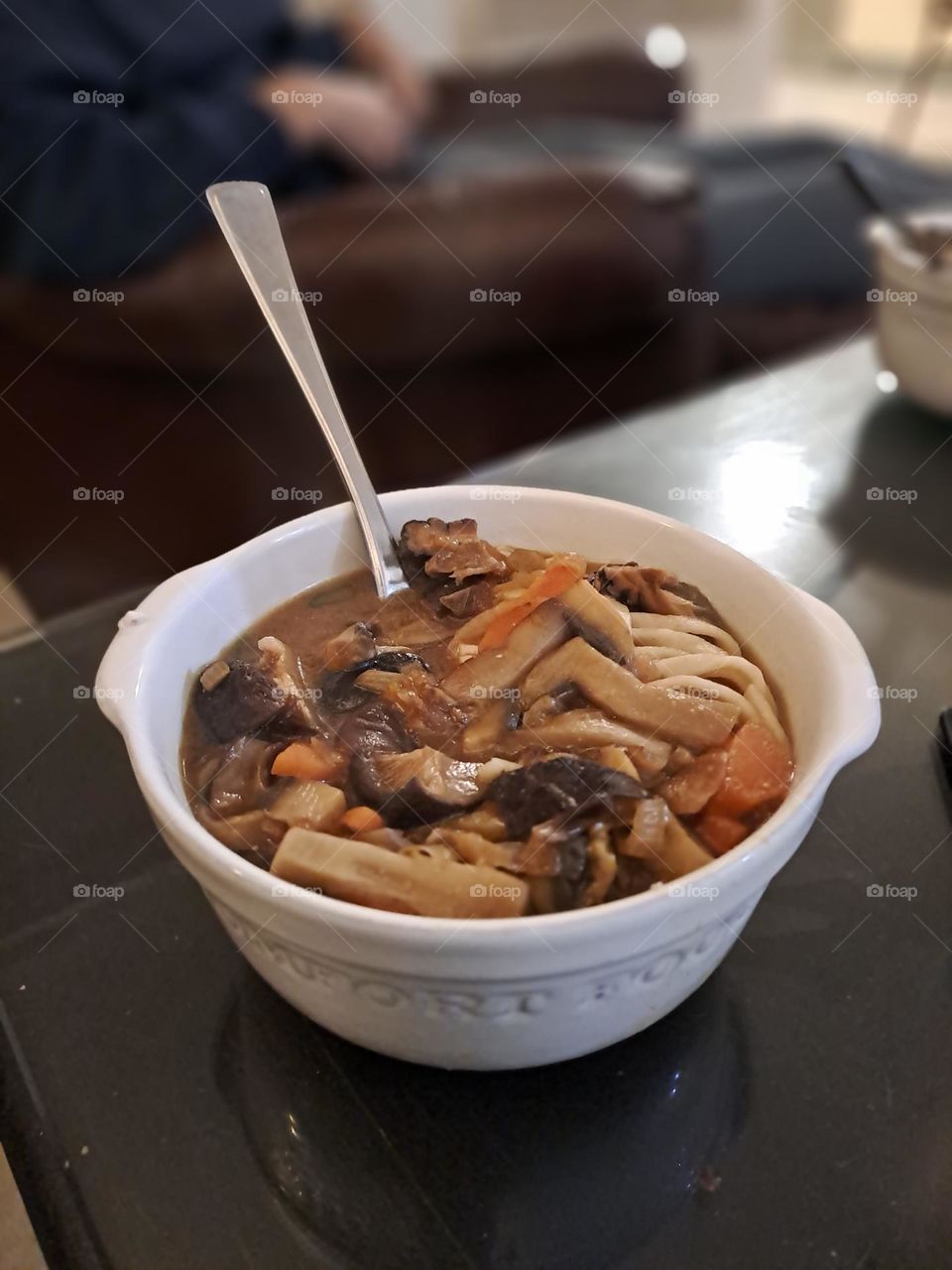 miso soup in a white bowl on a black glass table