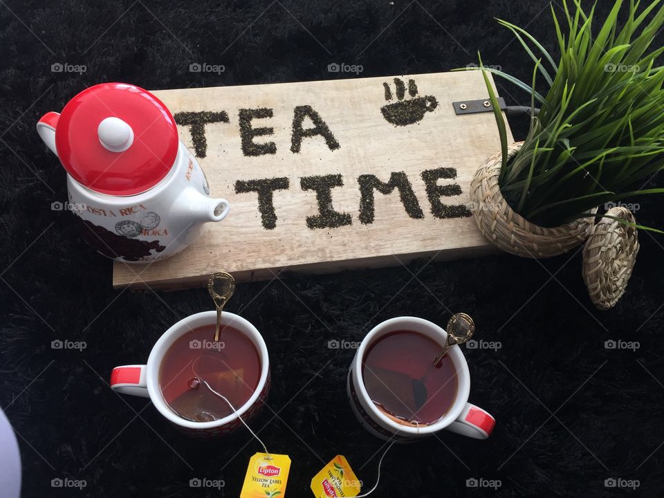High angle view of cup of tea with tea bags and teapot