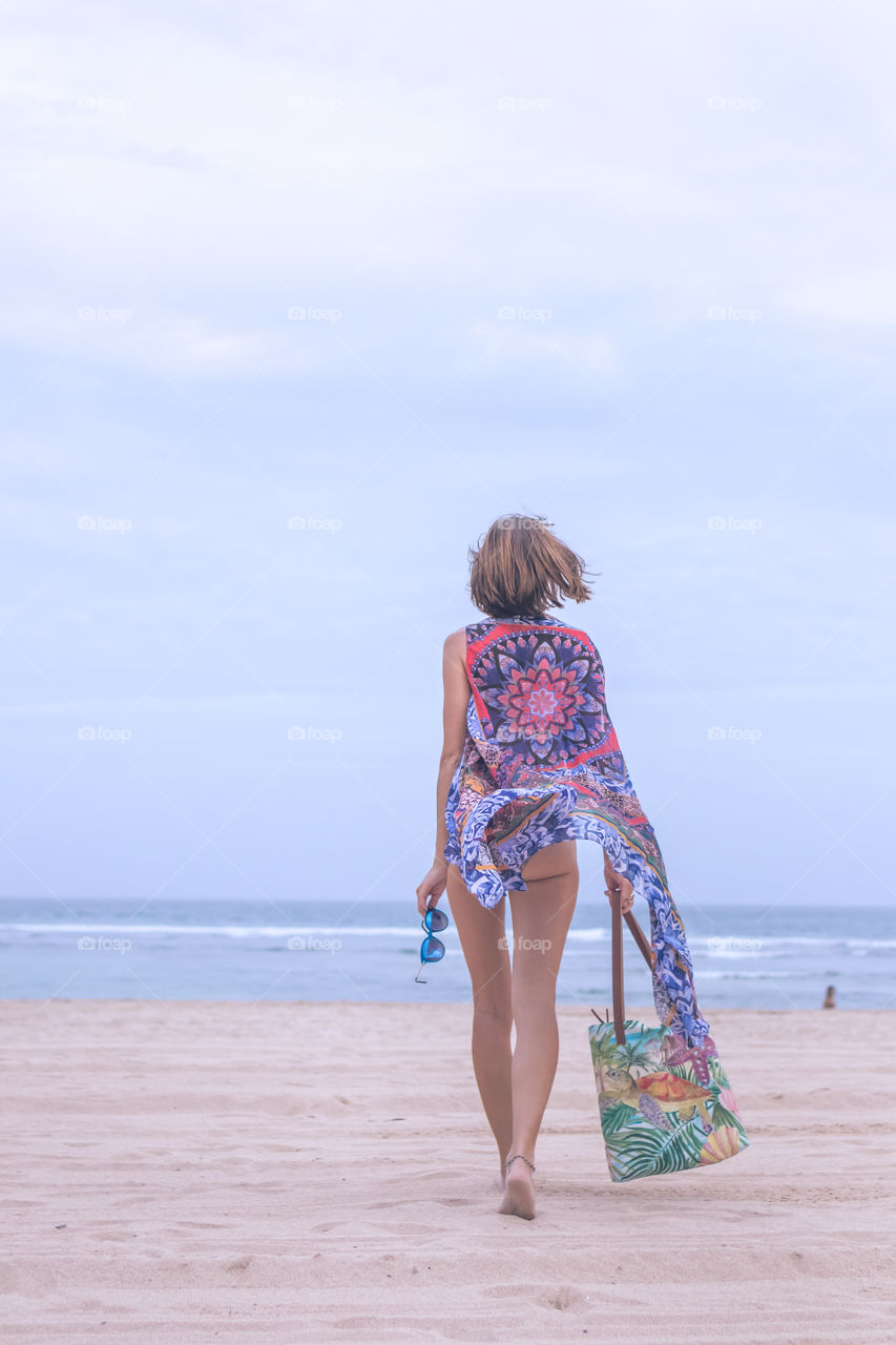 Girl walking on the beach. Nusa-Dua, Bali island.