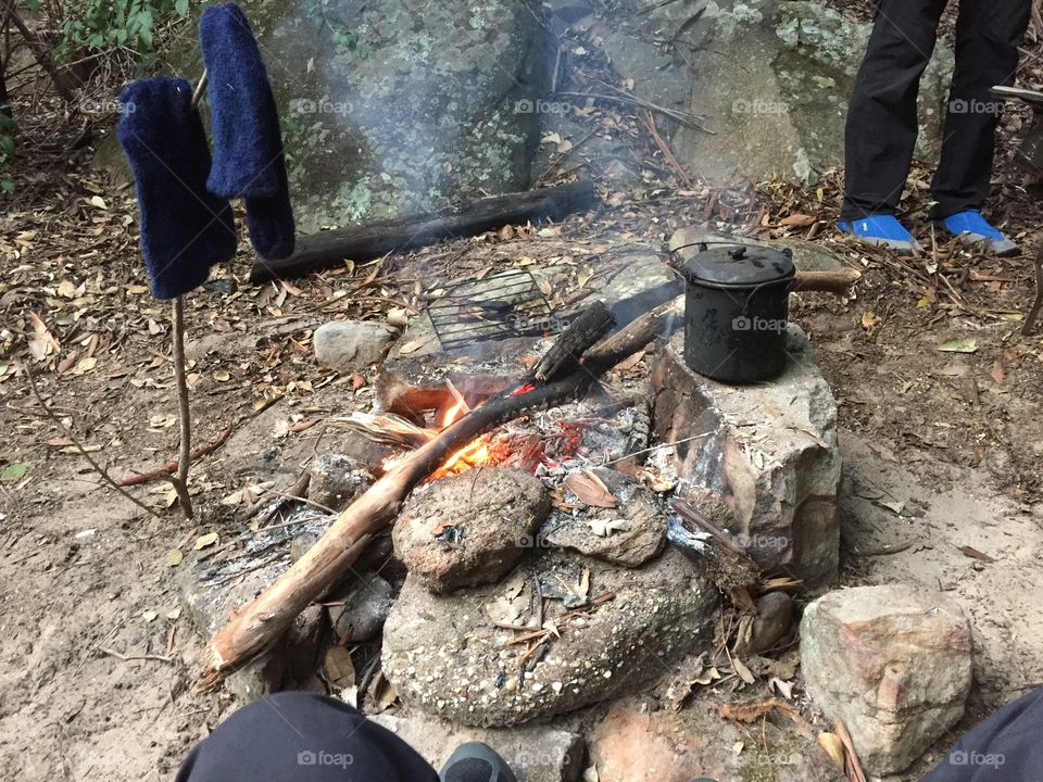 Small campfire with rocks and a billy boiling 