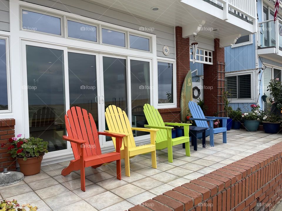 Wooden armchairs in pride colors near the house 