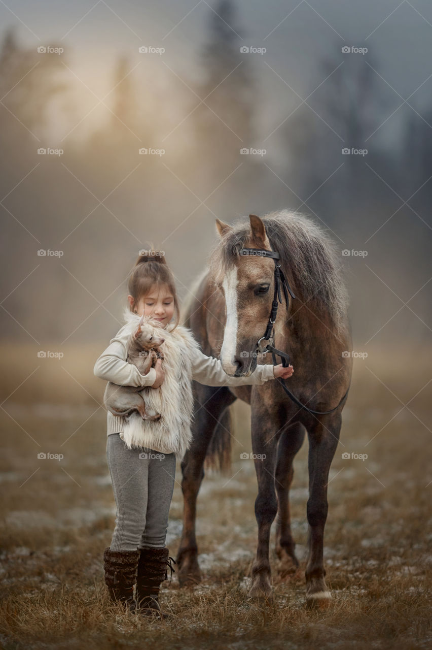 Portrait of little girl with  horse